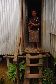 Girl with cat at house entrance, Papua New Guinea