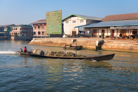 NYAUNG SHWE, INLE LAKE, MYANMAR (Burma) - 07 JAN 2014: Shipping wooden long boat with motor with cargo. Boats is a key transport type on Inle lake. 