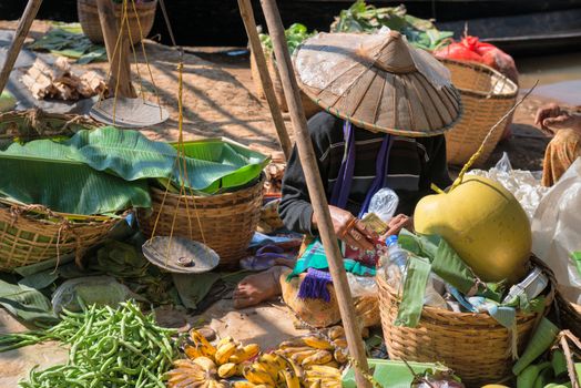 Local Burmese Intha woman sell vegetable on a traditional open market in dollars. Local markets serves most common shopping needs Inle Lake people.