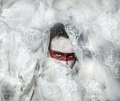 Mystery, covered with white lace veil, red makeup man mask