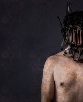 naked man with helmet made of forks