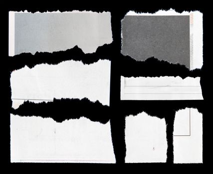 Pieces of torn paper on black. Copy space