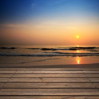 Wooden floor with beach at sunrise