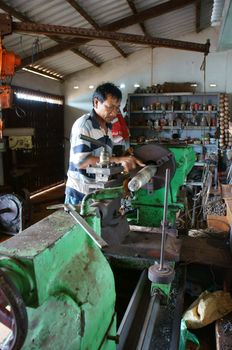 BINH THUAN, VIETNAM- JAN 21: Mechanic working with machine in private mechanical workshop, this place repair mechanic part for fishing boat in Viet Nam, Jan 21, 2014