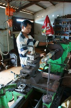 BINH THUAN, VIETNAM- JAN 21: Mechanic working with machine in private mechanical workshop, this place repair mechanic part for fishing boat in Viet Nam, Jan 21, 2014