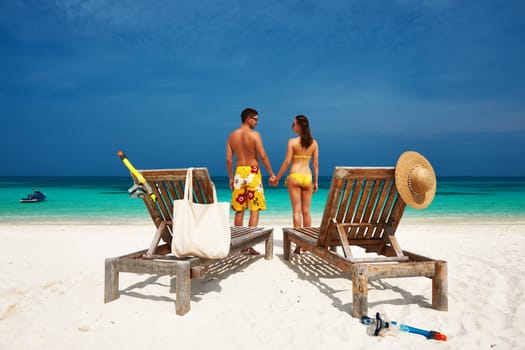 Couple in yellow on a tropical beach at Maldives