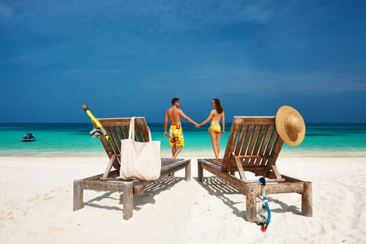 Couple in yellow on a tropical beach at Maldives