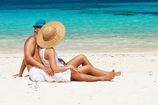 Couple in white relax on a tropical beach at Maldives