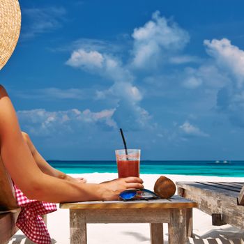 Woman at beautiful beach with chaise-lounges