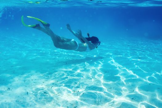 Woman with mask snorkeling in clear water 