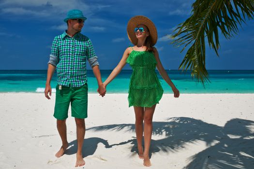 Couple in green on a tropical beach at Maldives