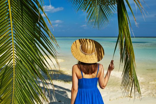 Woman in blue dress on a tropical beach at Maldives