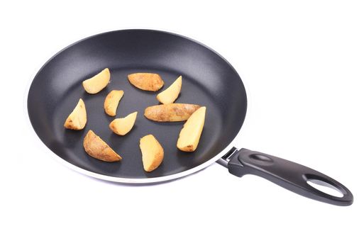 Fried potatoes on a black frying pan. On a white background.