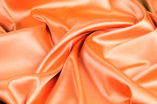 orange silk background with some soft folds and highlights