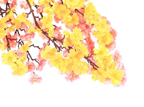 Artificial branch with yellow and pink flowers. On a white background.