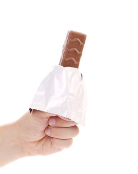 Hand holds dark chocolate bar in foil. Isolated on a white background