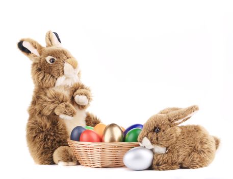 Toy rabbits with a basket of Easter eggs. Isolated on a white background.