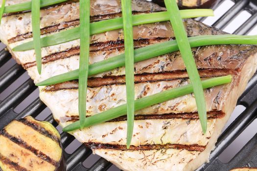 Grilled carp fillet on grill with egg plant. Whole background.