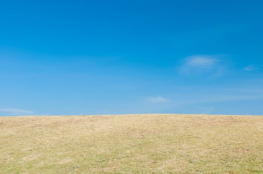 Green sloping  meadows and clouds with blue sky