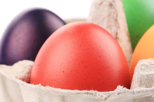 Cardboard egg box with Easter colored eggs. close up