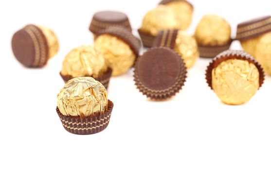 Bunch of chocolate gold bonbons. Blurred. Whole background.