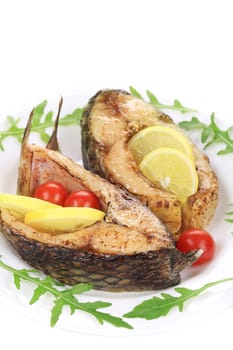 Carp steaks with herbs and lemon. Isolated on a white background.