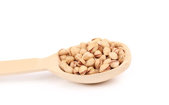 Wooden spoon with pistachios. Isolated on a white background.