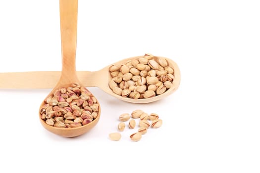 Close up of spoons with pistachios. Isolated on a white background.
