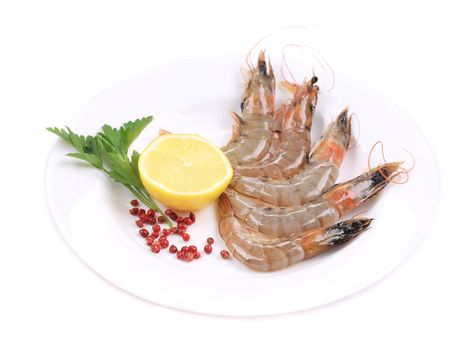 Raw shrimp with lemon and parsley. Isolated on a white background.