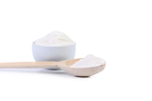 Spoon and bowl with flour. Isolated on a white background.