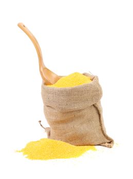 Cornmeal in burlap with wooden spoon. Isolated on a white background.