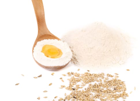 Flour and yolk in wooden spoon. Isolated on a white background.