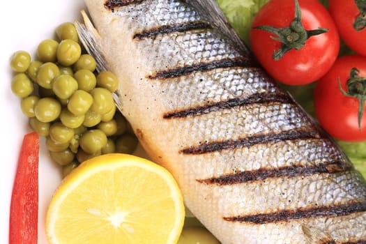 Grilled fish and vegetables. Isolated on a white background.