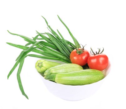 Courgettes, spring onions and tomatoes. Isolated on a white background.
