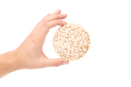 Hand holds puffed wheatbread. Isolated on a white background.