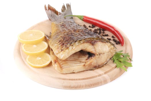 Grilled carp with lemon and peppers. Isolated on a white background.