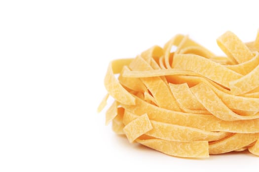 A portion of tagliatelle italian pasta closeup. Isolated on a white background.