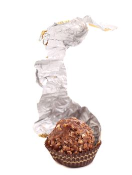 Sweet chocolate candy unwrapped in silver foil. Isolated on a white background.