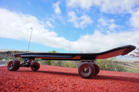 Vintage Style Longboard Black Skateboard on an Empty Asphalt Desert Road