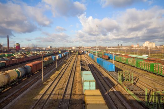 Freight train with color cargo containers passing railway station