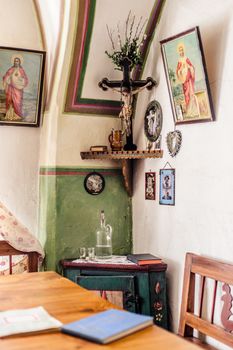 Rural living room with crucifix and religious paintings
