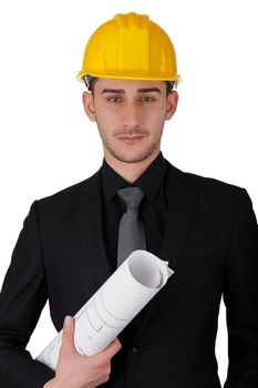 Young man wearing a hard hat and holding a roll of blueprints