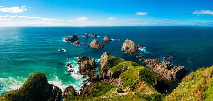 Nugget Point is located in the Catlins area on the Southern Coast of New Zealand, Otago region. The area is famous for many rock islands - nuggets - in the sea. Panoramic photo