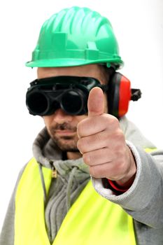 Worker with protective gear and thumbs up