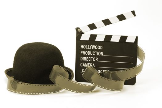 Bowler hat and movie clapper over white . Black and white picture