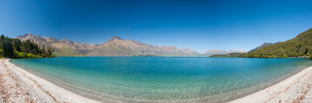 Beautiful lake Wakatipu with mighty mountains on horizon. Otago region, New Zealand. Panoramic photo