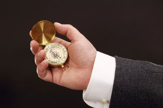 hand of a businessman holding a compass