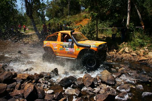 BAO LOC, VIETNAM- FEB 24: Racer at terrain racing car competition,motor cross stream that extreme off road with rock on water, competitor  adventure in championship spirit, Viet Nam, Feb 24, 2014