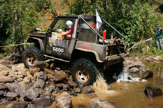 BAO LOC, VIETNAM- FEB 24: Racer at terrain racing car competition,motor cross stream that extreme off road with rock on water, competitor  adventure in championship spirit, Viet Nam, Feb 24, 2014