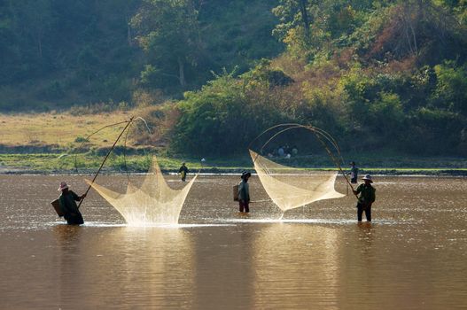 BUON ME THUOT, VIETNAM- FEB 7: People catch fish on ditch, fisherman lifting net from water, lift net is primitive traditional tool, include net, rod, four corner hang up 4 frame, Vietnam, Feb 7, 2014